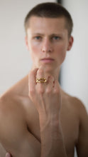 Load image into Gallery viewer, Close-up of a hand wearing a gold organic shaped ring on a neutral background
